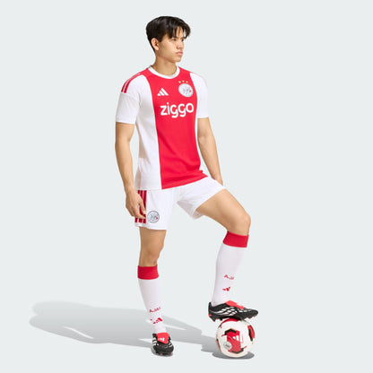 Adidas Ajax Amsterdam thuistenue voetbalshirt 2026 2027 met officiële clubdetails op model Kickoff Antwerpen
