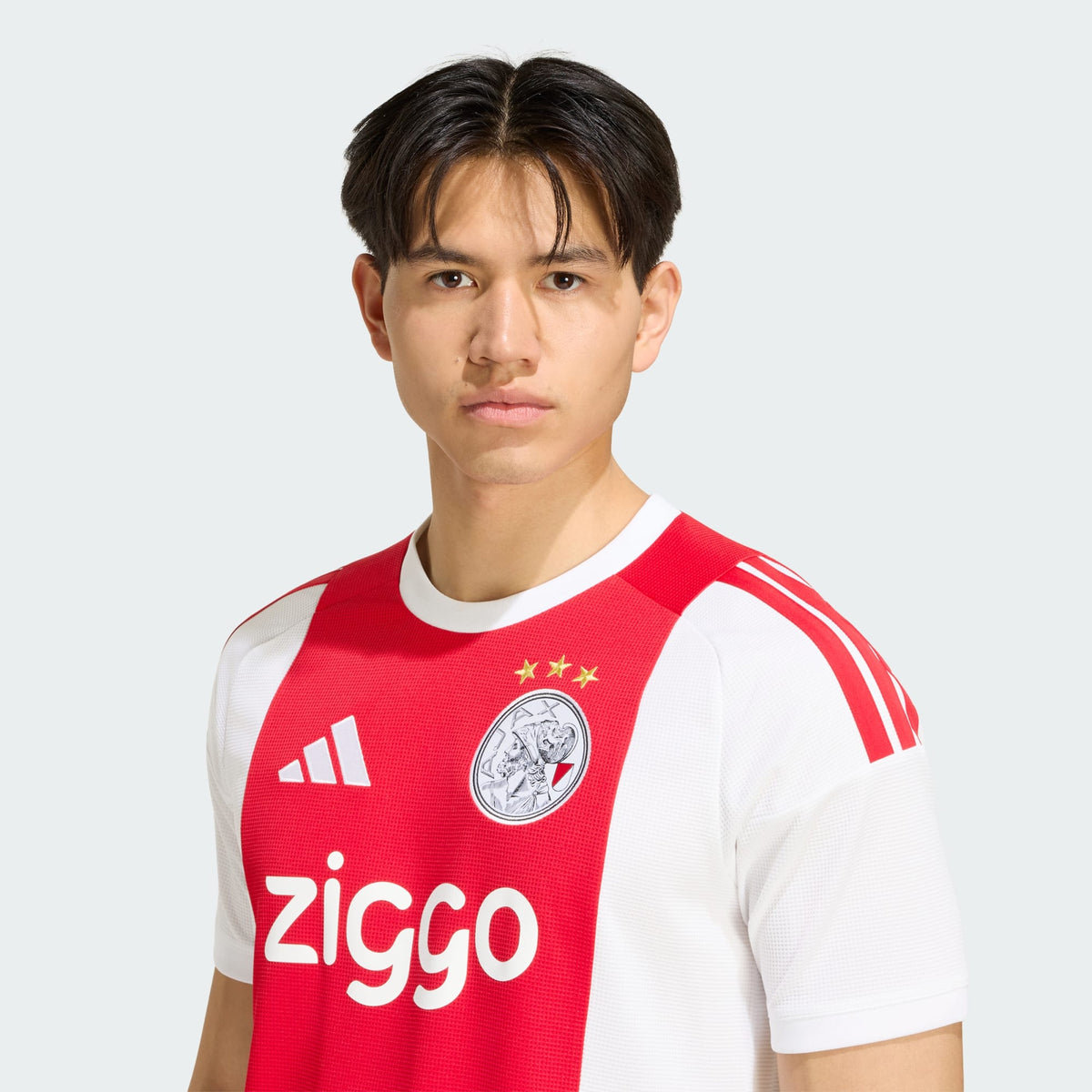 Adidas Ajax Amsterdam thuistenue voetbalshirt 2026 2027 met officiële clubdetails op model Kickoff Antwerpen
