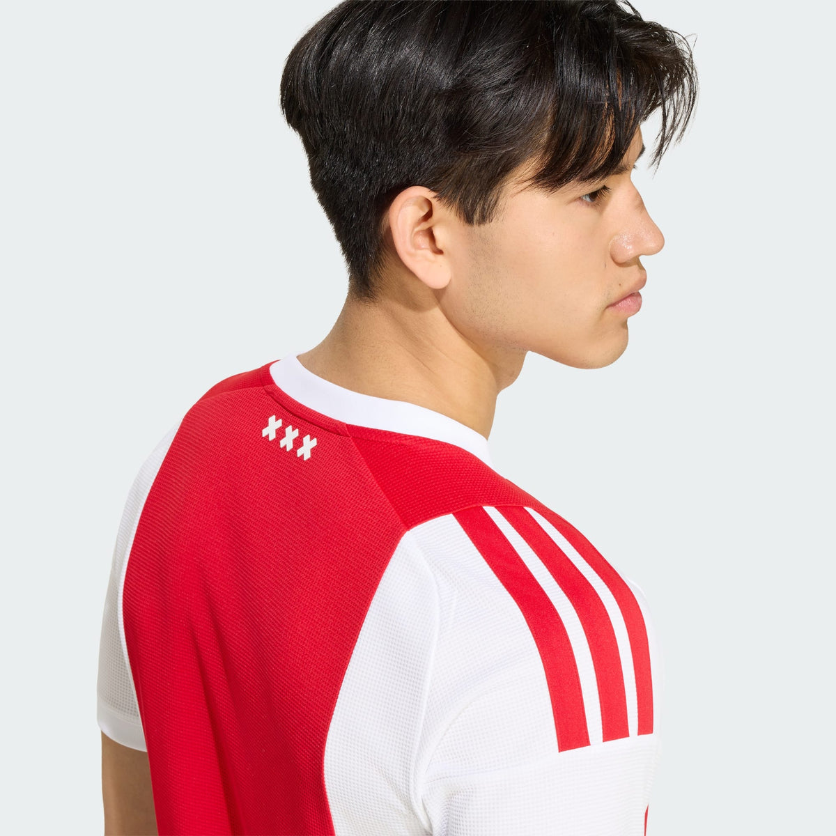 Adidas Ajax Amsterdam thuistenue voetbalshirt 2026 2027 met officiële clubdetails op model Kickoff Antwerpen