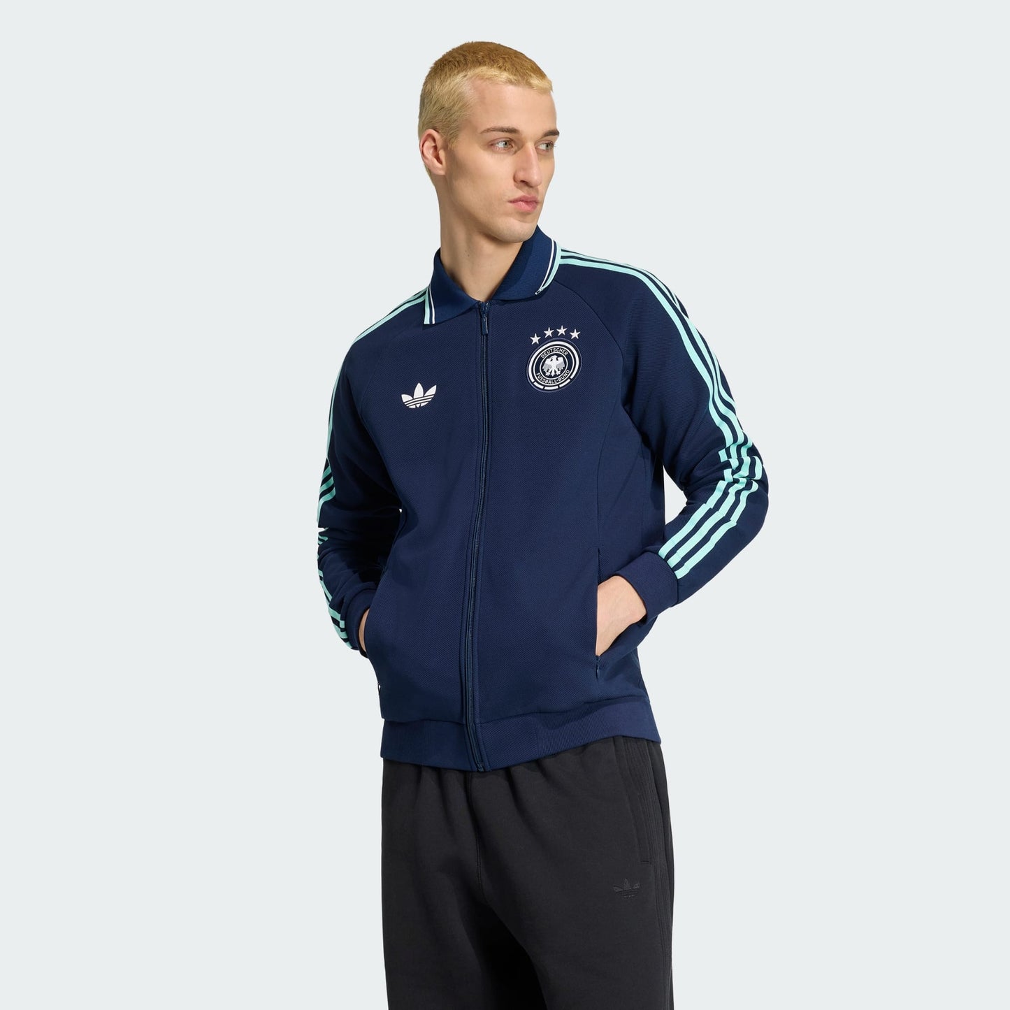 Witte Adidas Originals DFB Germany Anthem Jacket met zwart Trefoil-logo en Duitsland bondsembleem, verkrijgbaar bij voetbalshop Kickoff Antwerpen.