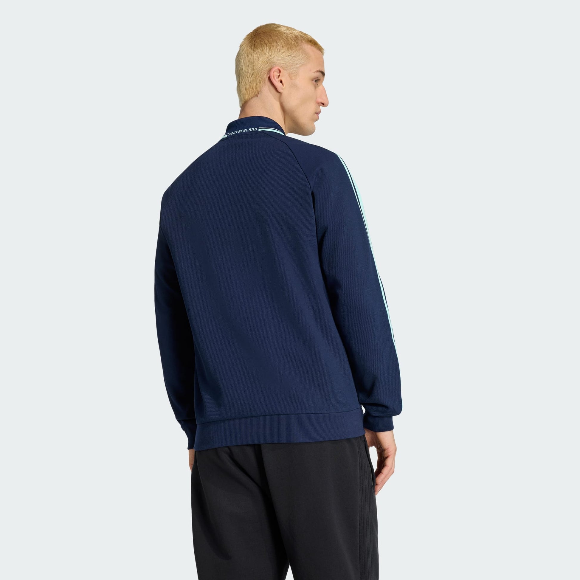 Witte Adidas Originals DFB Germany Anthem Jacket met zwart Trefoil-logo en Duitsland bondsembleem, verkrijgbaar bij voetbalshop Kickoff Antwerpen.