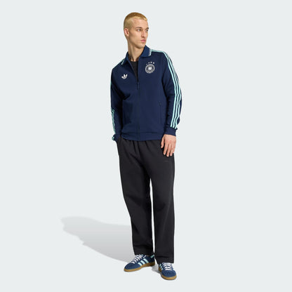 Witte Adidas Originals DFB Germany Anthem Jacket met zwart Trefoil-logo en Duitsland bondsembleem, verkrijgbaar bij voetbalshop Kickoff Antwerpen.