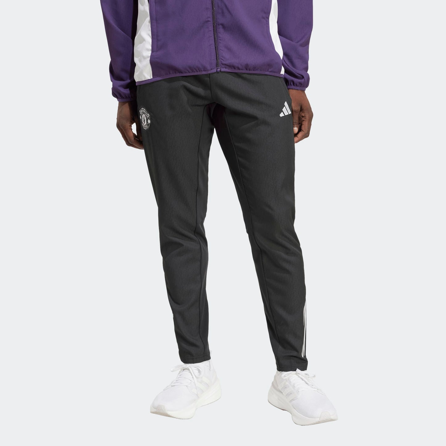 Adidas Manchester United Presentation Pants 2025-2026 heren trainingsbroek zwart met paars officieel Man Utd logo, Kickoff Antwerpen de voetbalshopo.