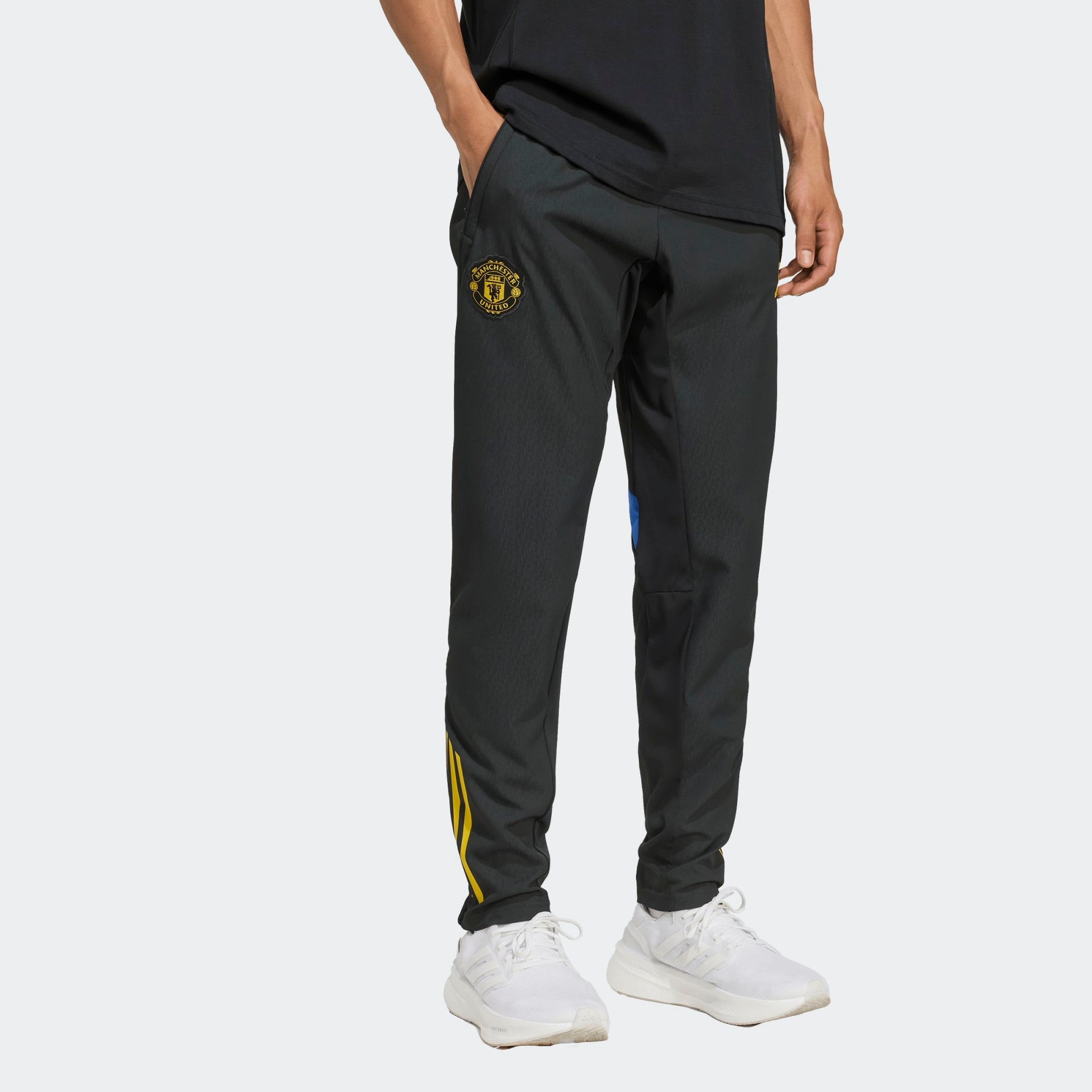 Adidas Manchester United EU Presentation Pants 2025/2026 zwarte taps toelopende trainingsbroek met clublogo Kickoff Antwerpen voetbalshop