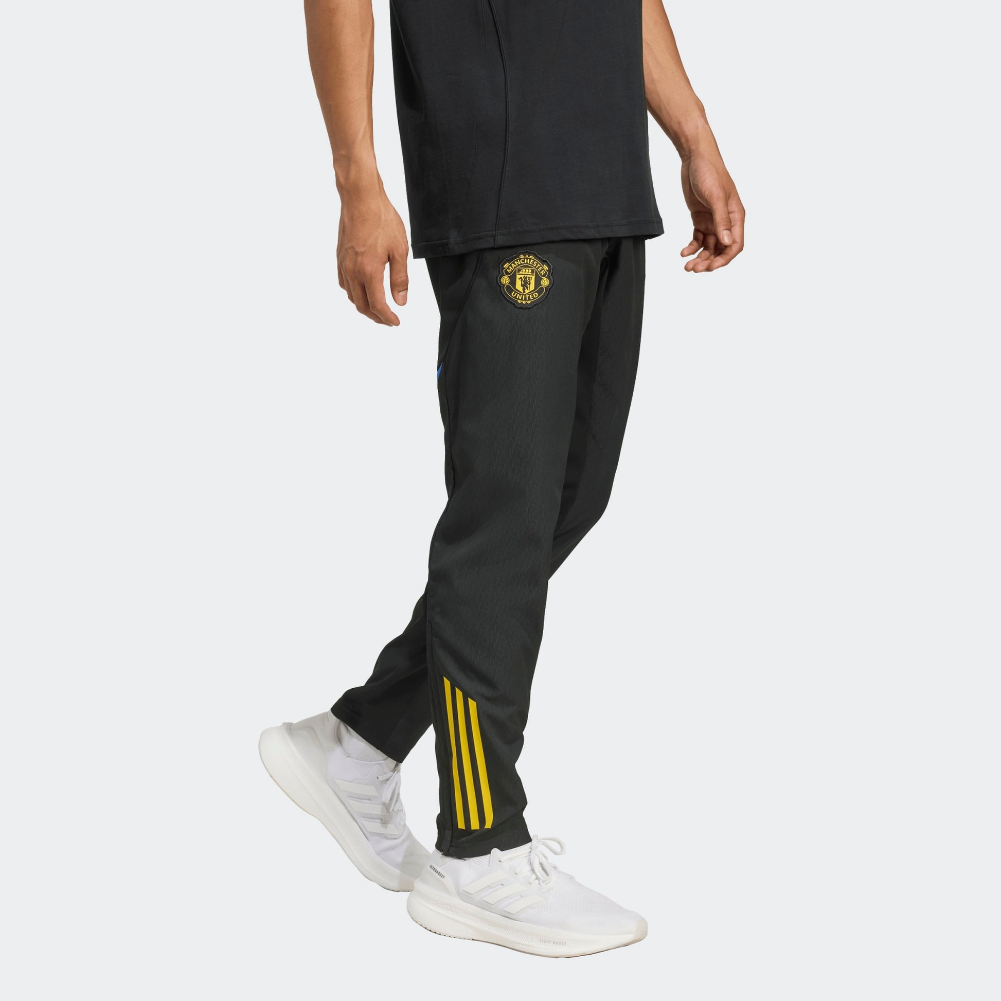 Adidas Manchester United EU Presentation Pants 2025/2026 zwarte taps toelopende trainingsbroek met clublogo Kickoff Antwerpen voetbalshop