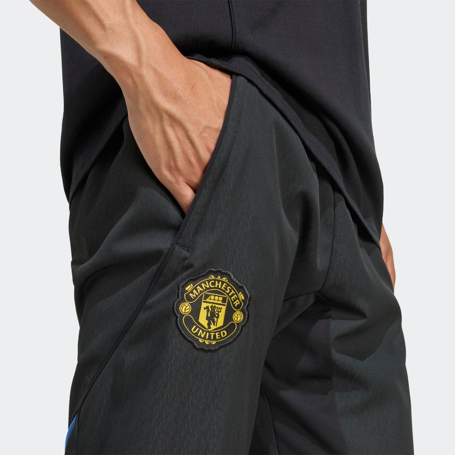 Adidas Manchester United EU Presentation Pants 2025/2026 zwarte taps toelopende trainingsbroek met clublogo Kickoff Antwerpen voetbalshop