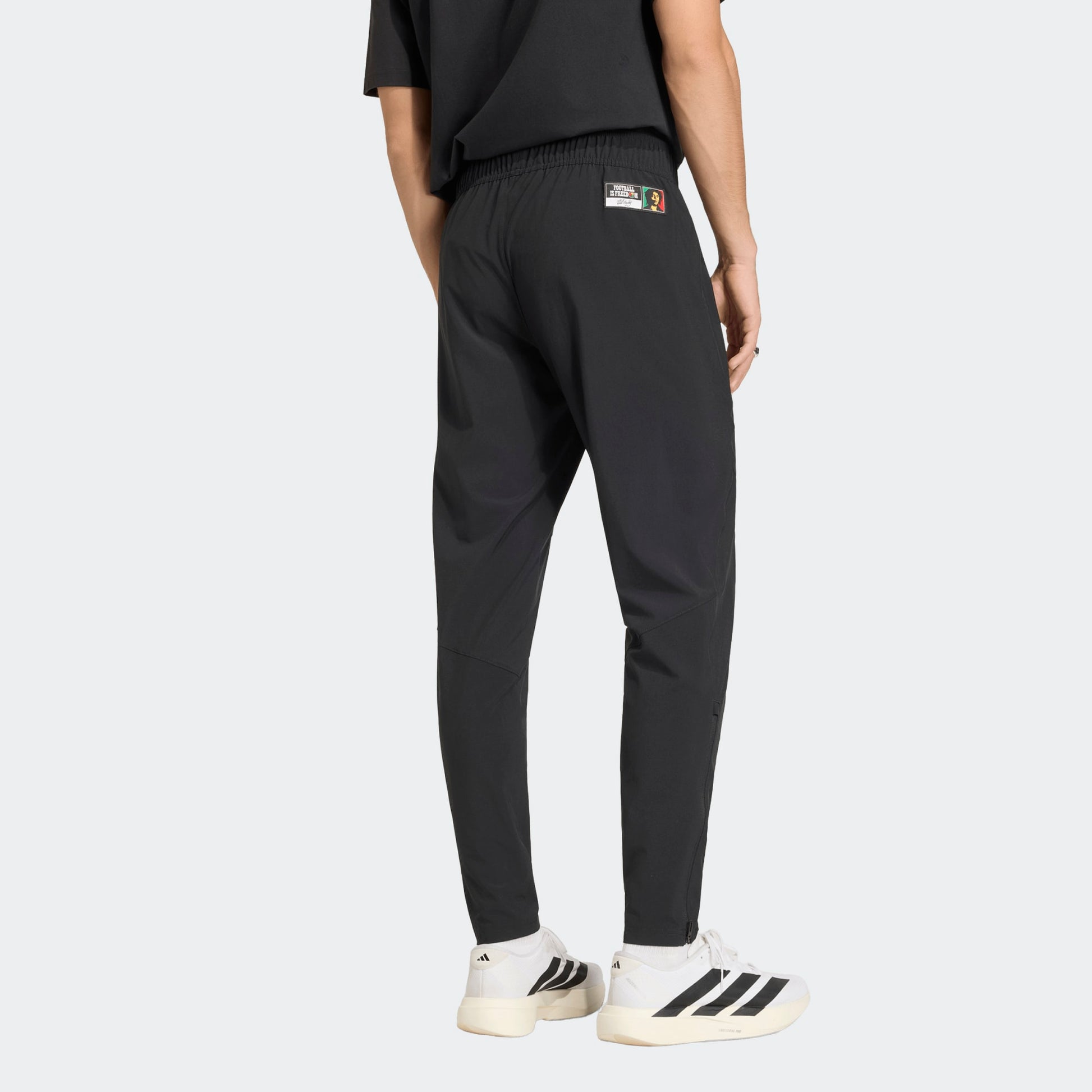 Zwarte Adidas JFF Jamaica Tracksuit Pants met geel-groene details, ode aan Bob Marley, verkrijgbaar bij voetbalshop Kickoff Antwerpen