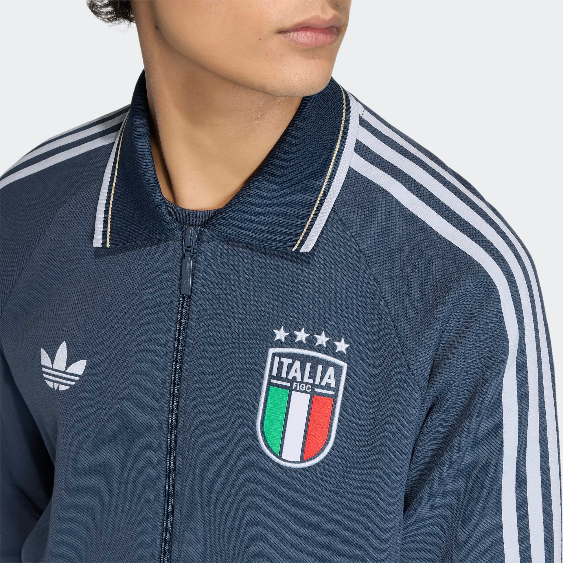 Blauw Adidas Originals FIGC Italia Anthem Jacket met retro Italiaanse bondbadge en witte 3-Stripes, verkrijgbaar bij voetbalshop Kickoff Antwerpen.