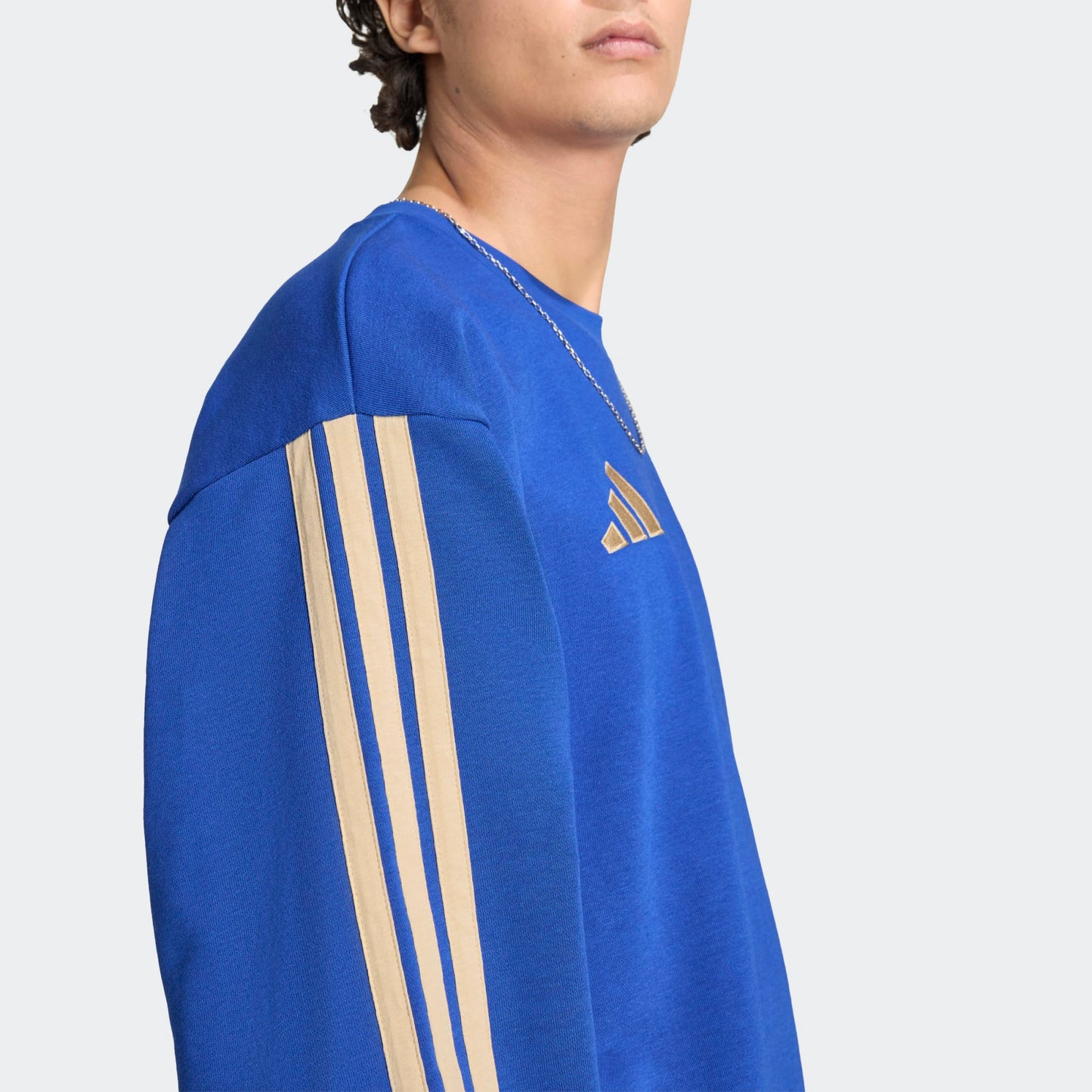 Adidas FIGC Italia DNA Sweat Top blauw met goud 3-Stripes en geborduurde Italiaanse voetbalbond (FIGC) badge. Beschikbaar bij voetbalshop Kickoff Antwerpen.