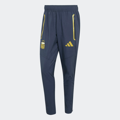 Adidas AFA Argentinië Travel Pants WK 2026 donker blauw met goud strepen en AFA-logo. Officiële voetbalbroek gedragen door de Argentijnse selectie tijdens reizen. kickoff antwerpen voetbalshop