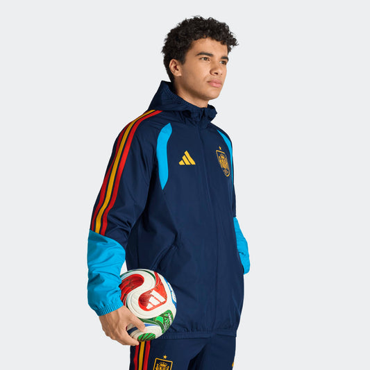 Adidas RFEF Spanje All-Weather Regenjas blauw met RFEF-logo en rode geel strepen WK 2026 collectie Kickoff Antwerpen voetbalshop