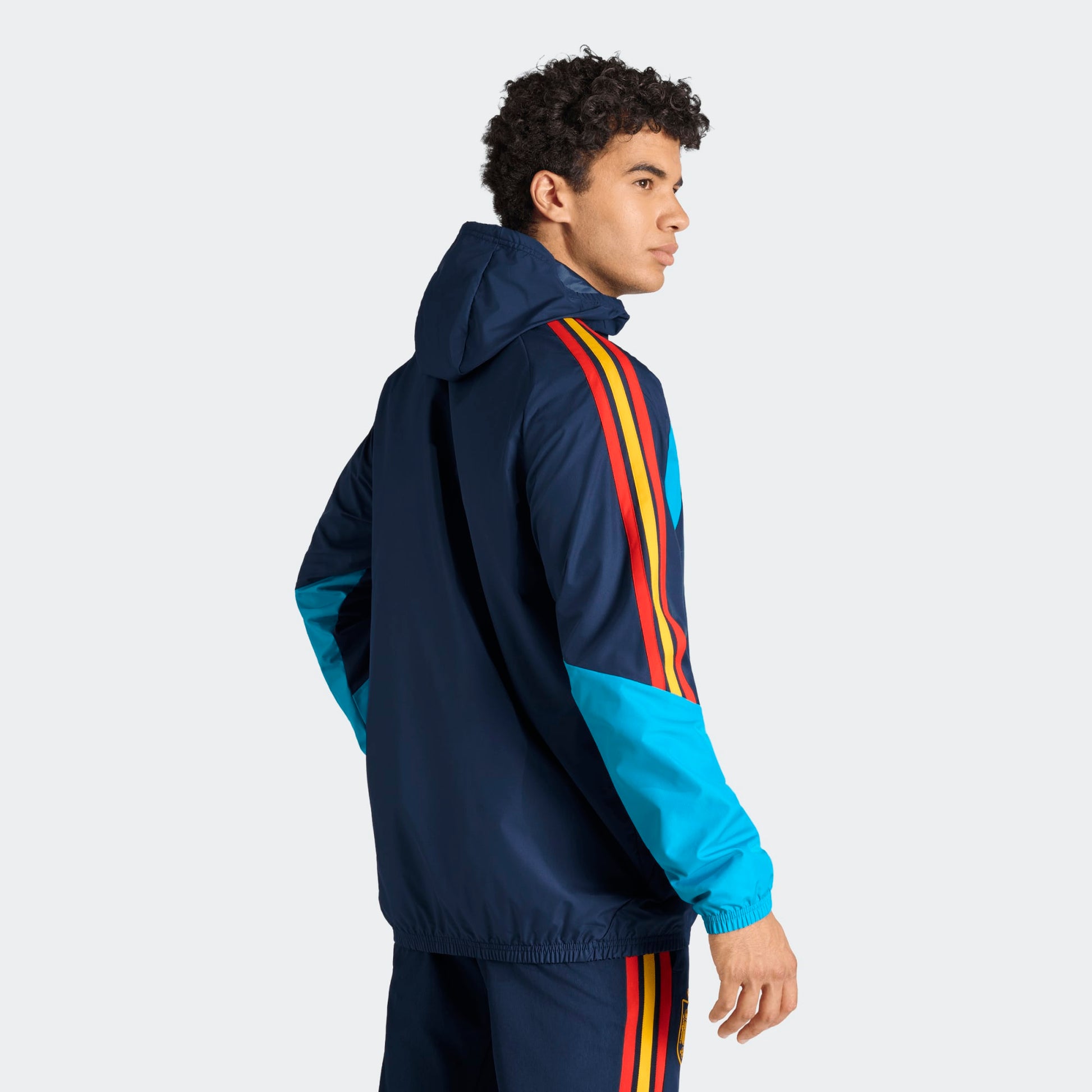 Adidas RFEF Spanje All-Weather Regenjas blauw met RFEF-logo en rode geel strepen WK 2026 collectie Kickoff Antwerpen voetbalshop
