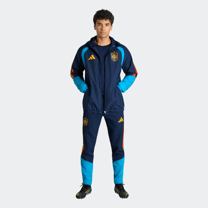 Adidas RFEF Spanje All-Weather Regenjas blauw met RFEF-logo en rode geel strepen WK 2026 collectie Kickoff Antwerpen voetbalshop