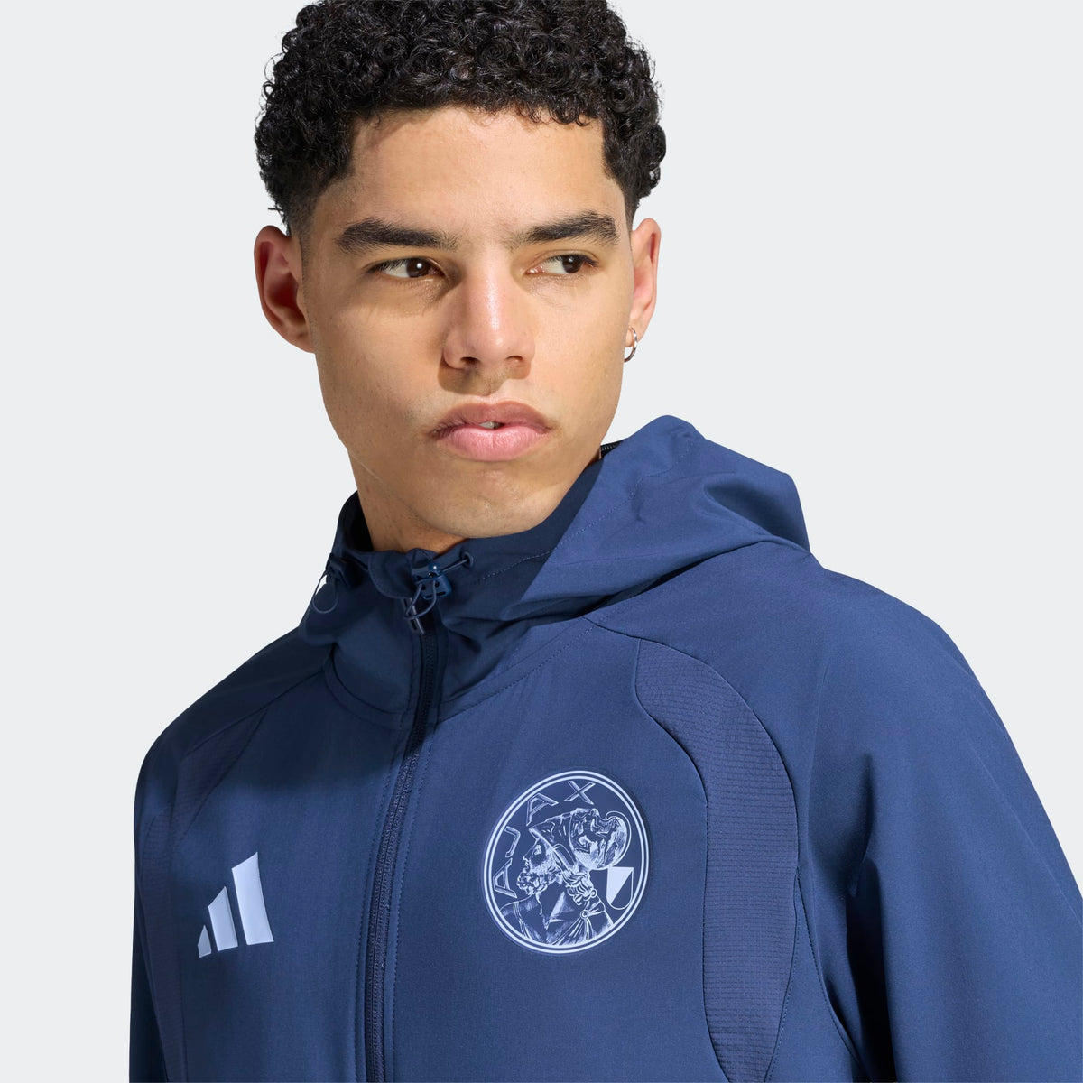 Adidas Ajax Amsterdam TT trainingspak 2026 2027 met clublogo en Adidas strepen op model Kickoff Antwerpen