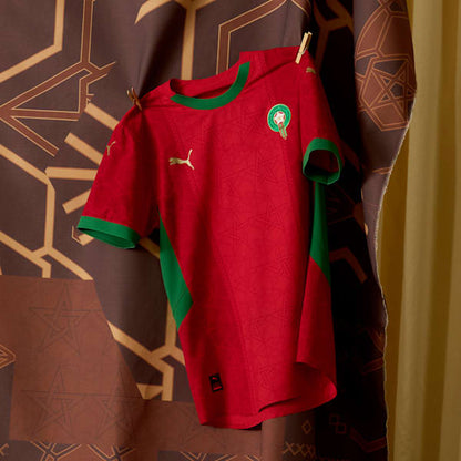 Puma Home Jersey Junior Marokkaans voetbalelftal 2025 met DryCELL-technologie, verkrijgbaar bij Kickoff Antwerpen – rood design met officiële teamdetails.