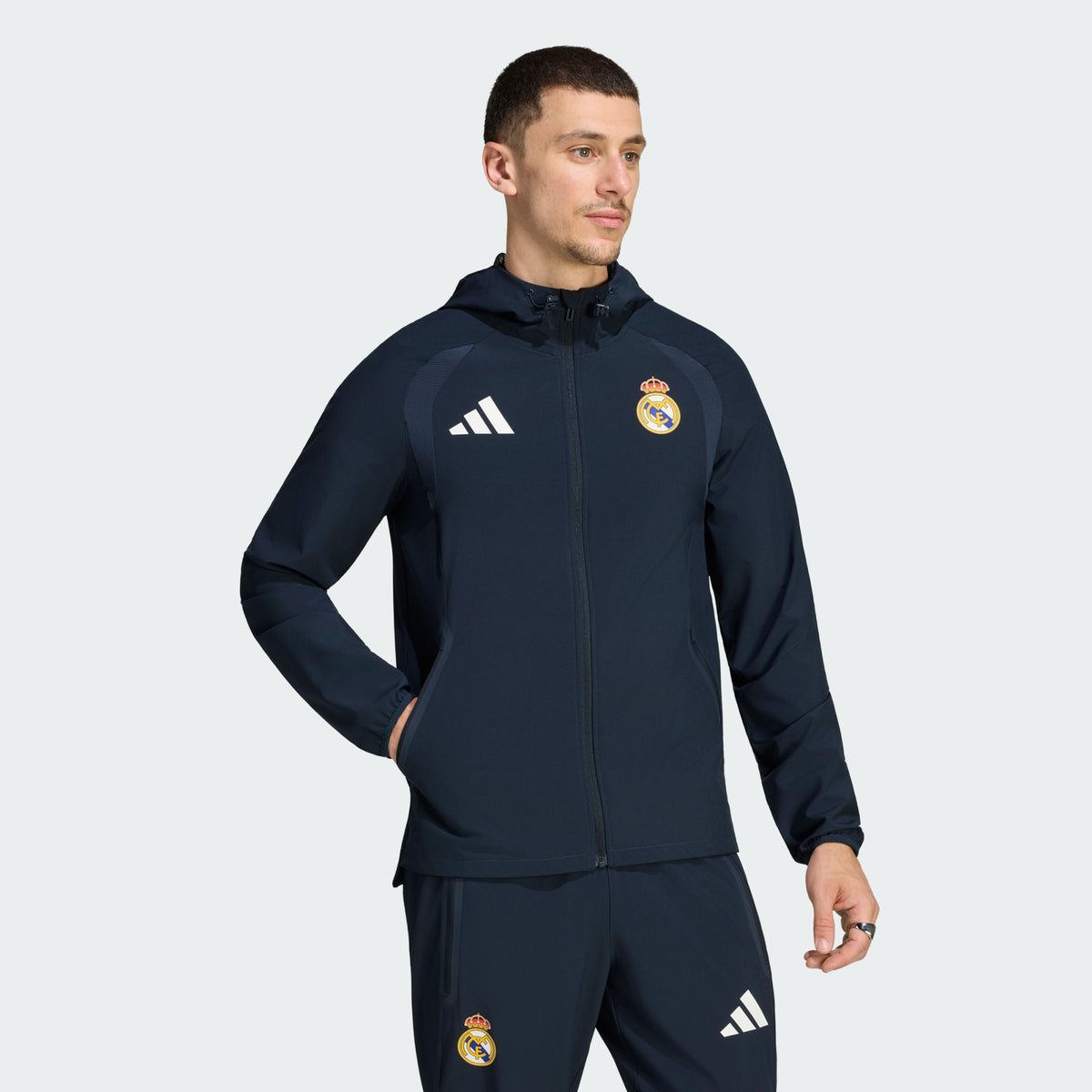 Adidas Real Madrid TT trainingspak 2026 2027 blauw met clublogo en Adidas strepen op model Kickoff Antwerpen