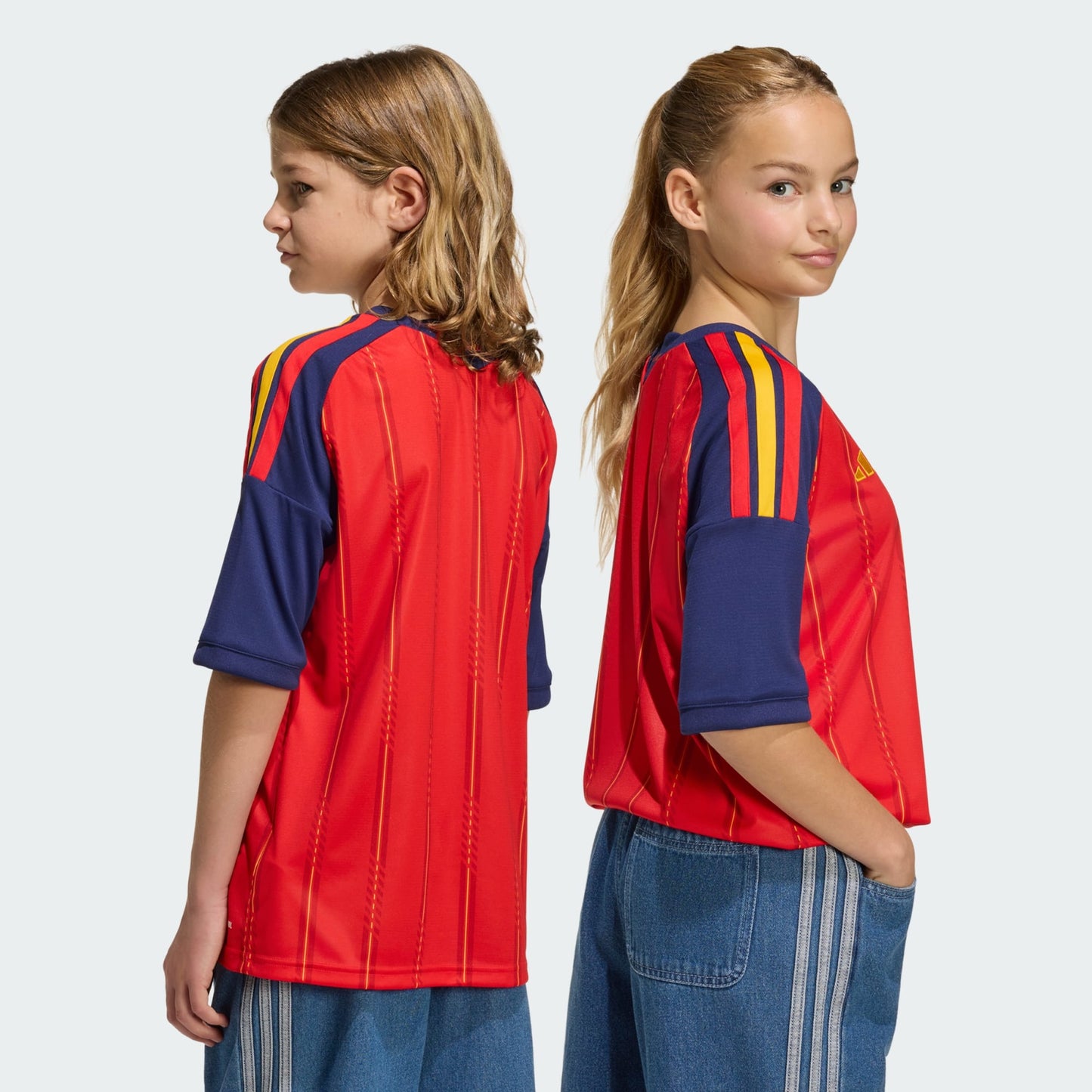 Rood Adidas RFEF Spanje Home Jersey voor kinderen 2026-2028 met geel bondsembleem en 3-Stripes, verkrijgbaar bij voetbalshop Kickoff Antwerpen.