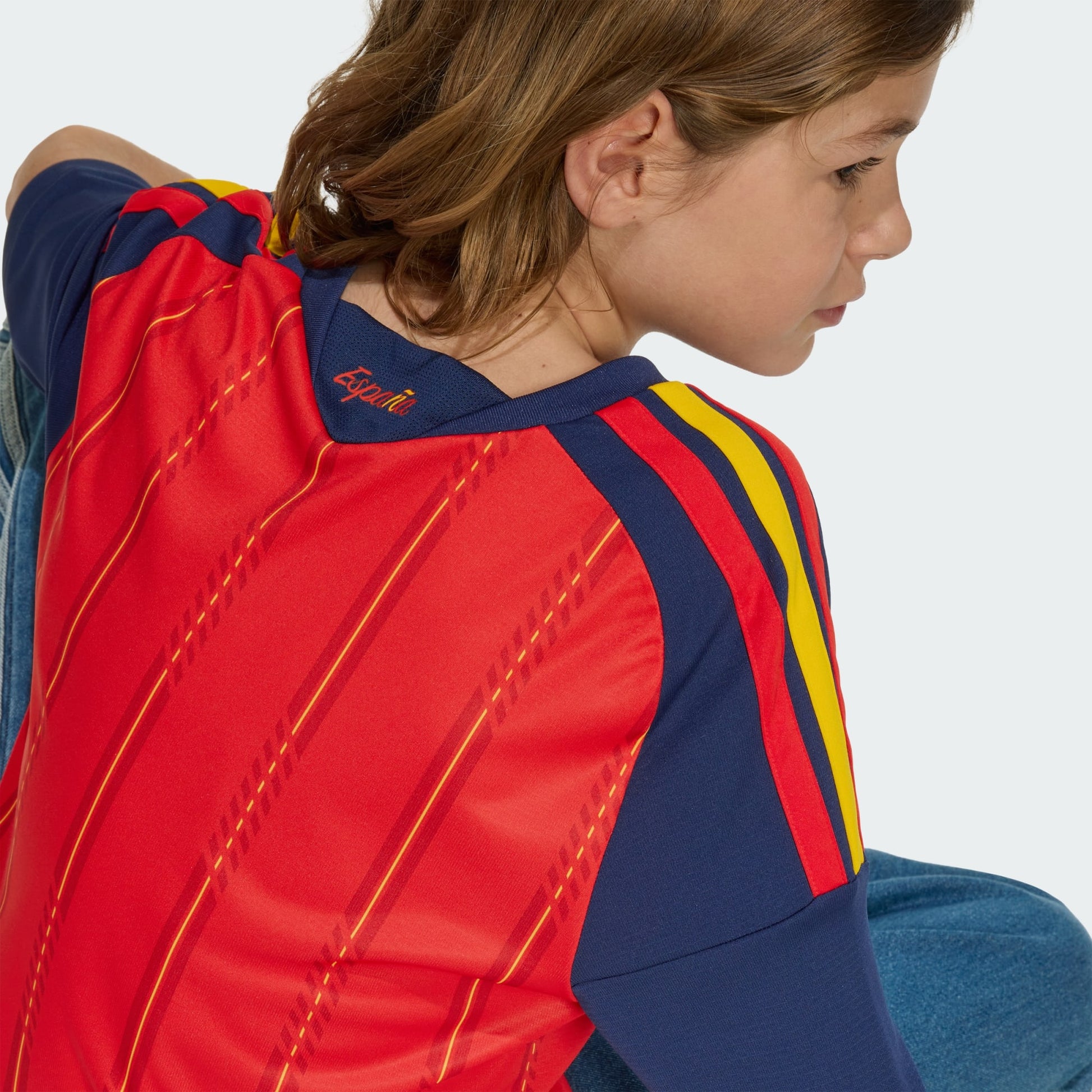 Rood Adidas RFEF Spanje Home Jersey voor kinderen 2026-2028 met geel bondsembleem en 3-Stripes, verkrijgbaar bij voetbalshop Kickoff Antwerpen.