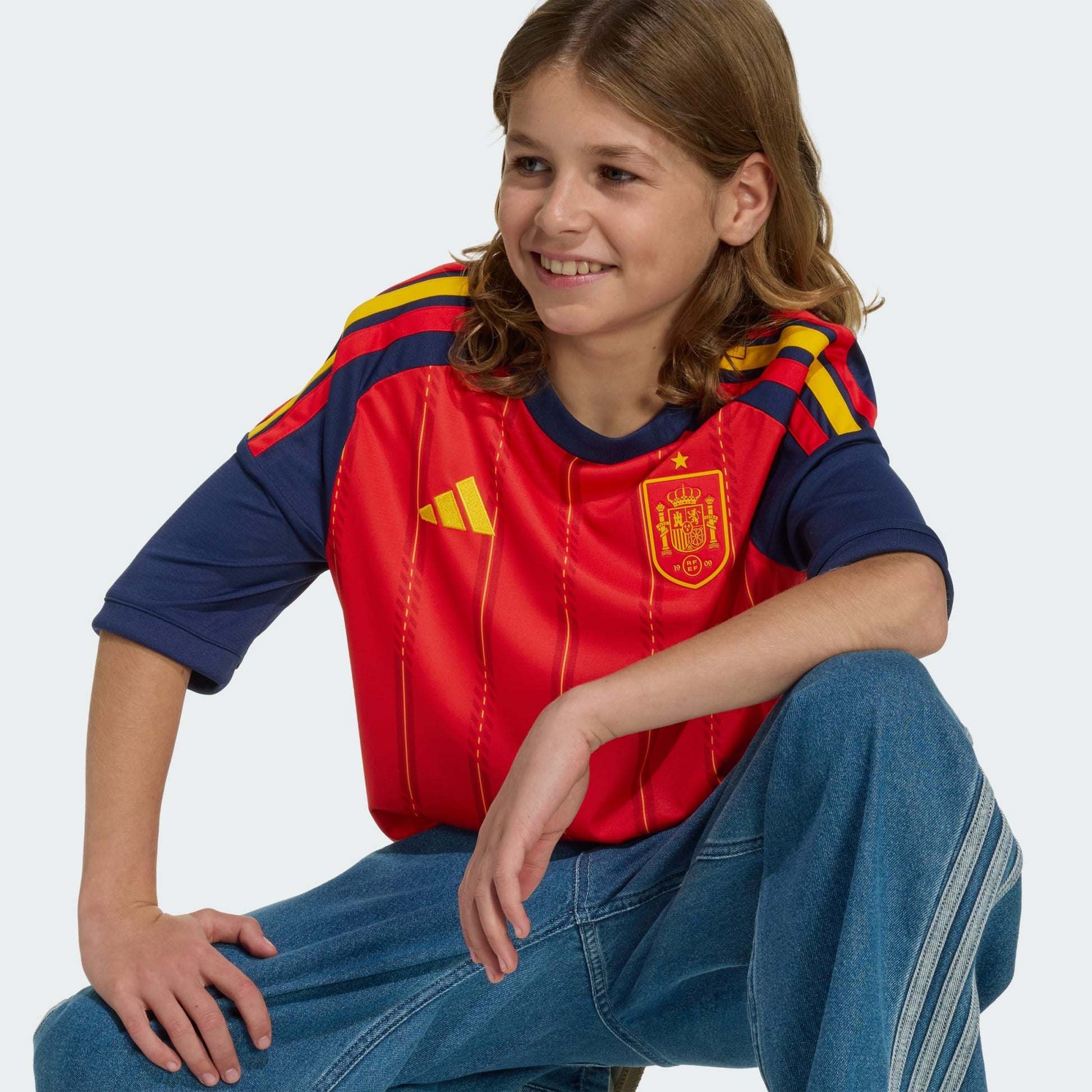 Rood Adidas RFEF Spanje Home Jersey voor kinderen 2026-2028 met geel bondsembleem en 3-Stripes, verkrijgbaar bij voetbalshop Kickoff Antwerpen.